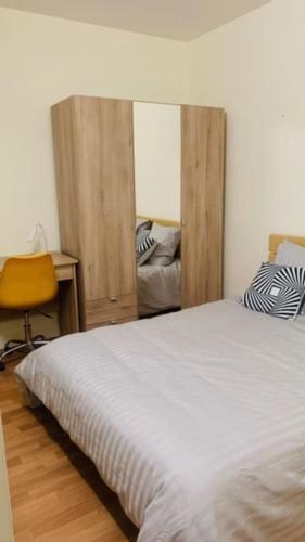 Schlafzimmer mit einem Bett, einem Schreibtisch und einem Stuhl in der Unterkunft Appartement calme et chaleureux proche de Paris in Courbevoie
