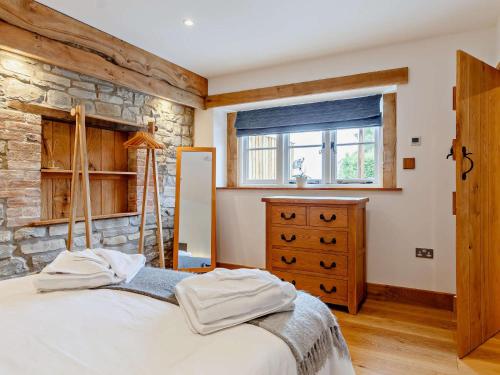 a bedroom with a bed and a stone wall at 1 Bed in Taunton 80693 in North Curry