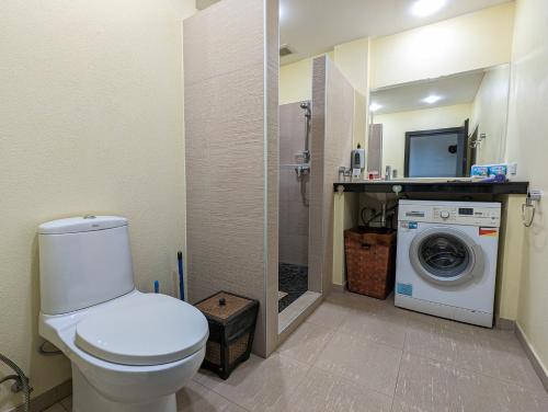 a bathroom with a toilet and a washing machine at Seaview Apartment in Siam Royal View in Ban Khlong Son