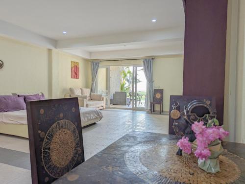 a living room with a bed and a table with flowers at Seaview Apartment in Siam Royal View in Ban Khlong Son
