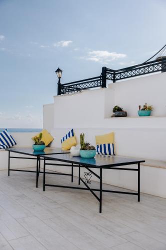 a table and a bench in a room with the ocean at Zima Blue in Zygi