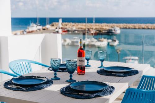 a table with a bottle of wine and plates and glasses at Zima Blue in Zygi