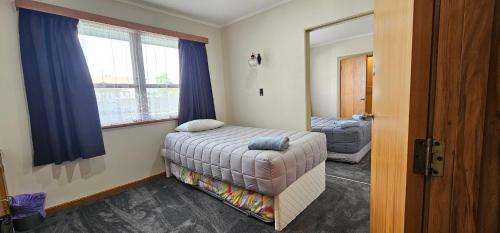 - une petite chambre avec un lit et une fenêtre dans l'établissement Whitehorse Inn, à Palmerston North