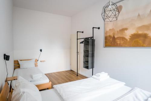 Three Bedroom plus big kitchen plus SelfCheckIn plus Street Parking في برلين: سريرين في غرفة بجدران بيضاء