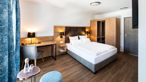 een hotelkamer met een bed en een bureau bij Schnitzers Dahoam - Hundefreundlich in Bad Wiessee