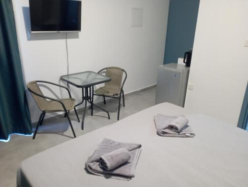 Cette chambre comprend deux lits, une table et des chaises. dans l'établissement BlueSuite, à Ayia Napa