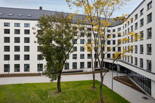 two trees in front of a white building at MILESTONE Krakow Center Student Living in Krakow