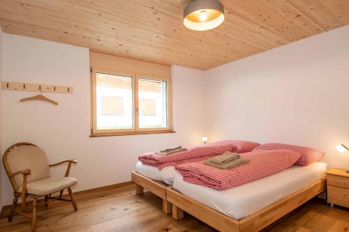 1 dormitorio con 1 cama y 1 silla en Ferienchalet Sonne en Adelboden