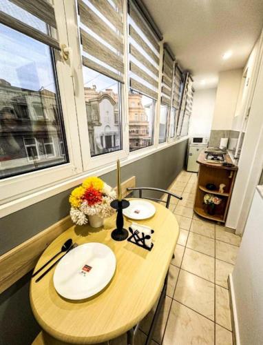 a table with two plates on it in a room with windows at Welcoming Central Studio with self check in in Bucharest
