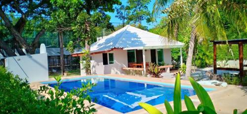 a villa with a swimming pool in front of a house at Nicha Pool Villa in Hua Hin