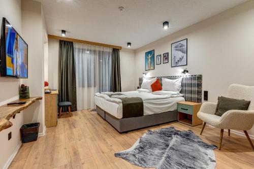1 dormitorio con cama, escritorio y silla en Mountain Lake Hotel, en Smolyan