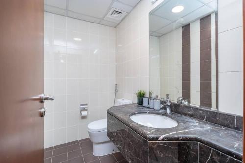 a bathroom with a sink and a toilet and a mirror at WOW! 1 Bed & Sofa Bed! 10-min walk to Dubai Mall in Dubai