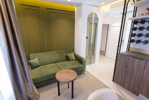 a living room with a green couch and a table at RIVA sleep & chill in Valjevo