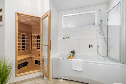 a white bathroom with a tub and a shower at Moin Moin in Olpenitz