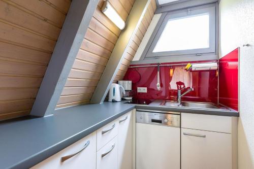 eine kleine Küche mit einem Waschbecken und einem Fenster in der Unterkunft Ferienwohnpark Immenstaad am Bodensee Nurdachhaus Typ 7 ND 56 in Immenstaad am Bodensee