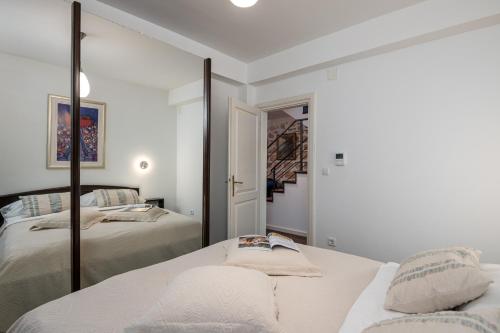 a white bedroom with two beds and a mirror at Villa Mirabilis, stunning superior villa, Dubrovnik Old Town in Dubrovnik