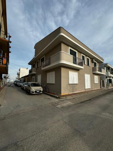 a building with a car parked in a parking lot at Villa Gina Case Vacanze in Roseto degli Abruzzi