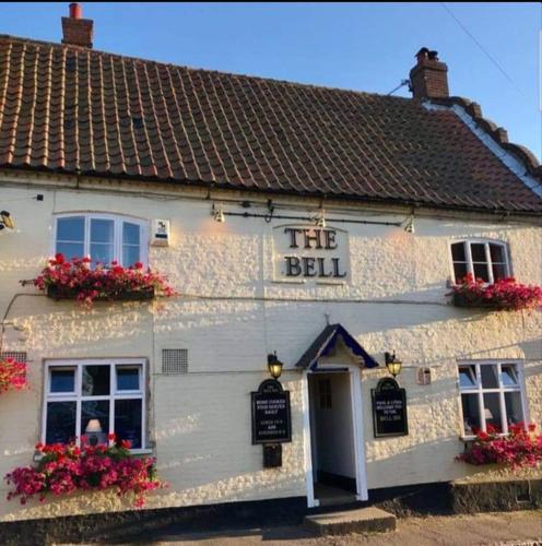 a white building with flowers in front of it at The Bell Inn in Norwich