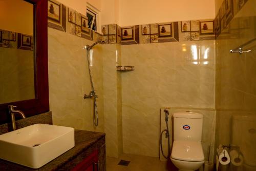 a bathroom with a toilet and a sink and a shower at Peacock Beach Hotel Unawatuna in Unawatuna