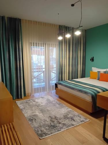 a bedroom with a bed and a large window at Anais Chalet in Câmpulung Moldovenesc