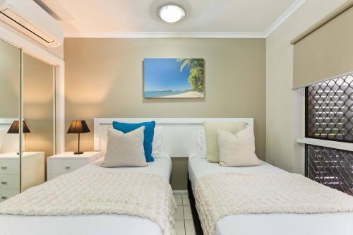 Mai at Coral Horizons: A Relaxed Beach Retreat في بالم كوف: غرفة نوم بسريرين مع وسائد بيضاء