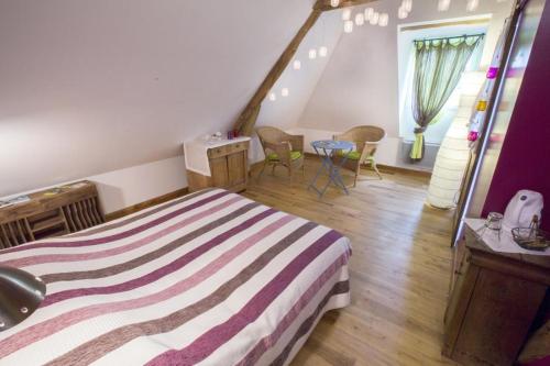 a bedroom with a bed and a table and chairs at Chambres d'hôtes du Coq à l'Ane in Beaubec-la-Rosière