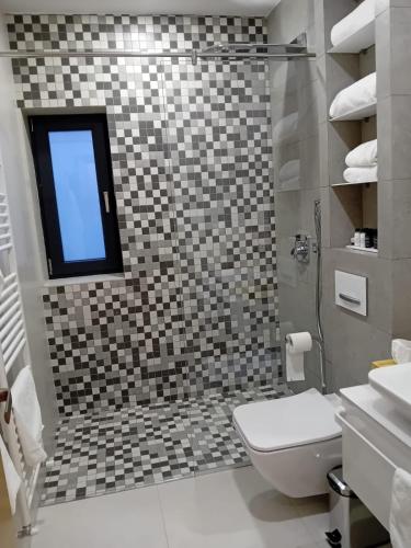 a bathroom with a toilet and a window at Anais Chalet in Câmpulung Moldovenesc