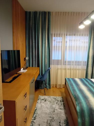 a hotel room with a bed and a desk with a television at Anais Chalet in Câmpulung Moldovenesc