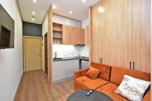 a living room with an orange couch and a kitchen at Aygestan plaza apartment 5 in Yerevan