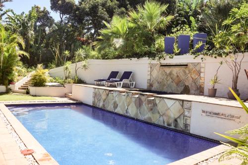 a swimming pool with two chairs in a backyard at The Terrace in East London