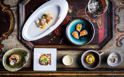 a table with plates of food and bowls of food at Romantik Hotel & Restaurant Stafler in Vipiteno