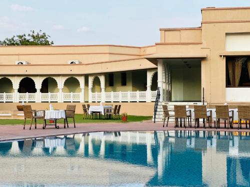 a resort with a pool and tables and chairs at Heritage Resort Bikaner in Bikaner