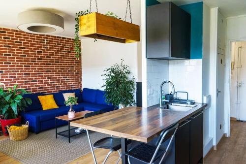 een keuken en een woonkamer met een blauwe bank bij Grand Appartement 4 Pièces à 10min Paris (80m2) in Vitry-sur-Seine