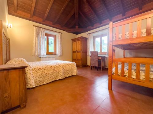 a bedroom with a bunk bed and a table at Amplia casa rural en entorno natural in Ziortza-Bolibar