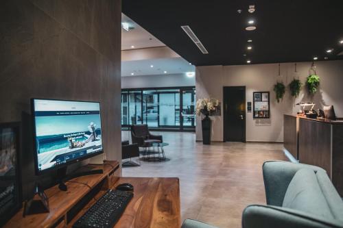 a living room with a tv and a computer on a table at Marvie Hotel & Health in Split