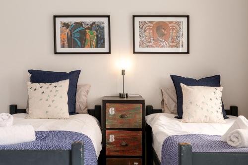 a bedroom with two beds and two pictures on the wall at Flamingo Beach in Swakopmund