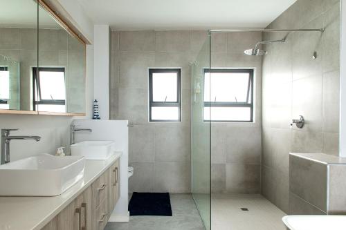 a bathroom with two sinks and a glass shower at Flamingo Beach in Swakopmund