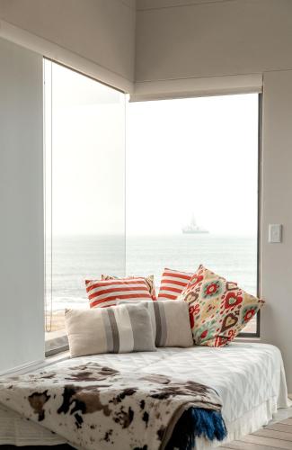 a bedroom with a bed with a view of the ocean at Flamingo Beach in Swakopmund