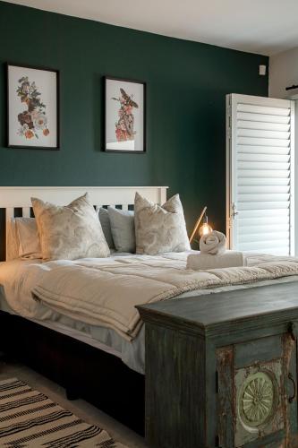 a bedroom with a large bed with a green wall at Flamingo Beach in Swakopmund