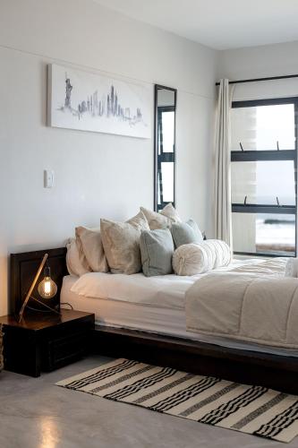 a white bedroom with a large bed and a window at Flamingo Beach in Swakopmund