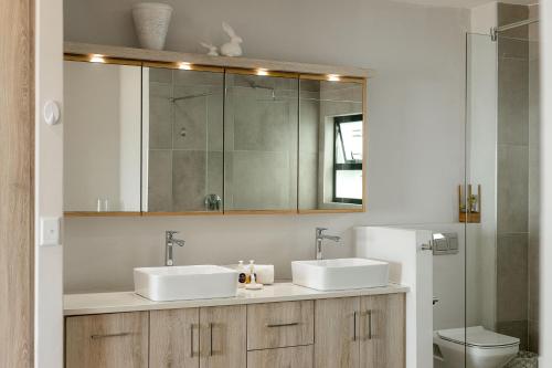 a bathroom with two sinks and a mirror at Flamingo Beach in Swakopmund
