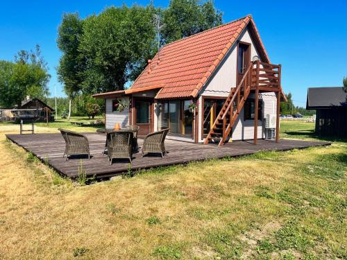 uma casa com cadeiras e uma mesa num deque em Rõsna Puhkekeskus em Suur-Rõsna