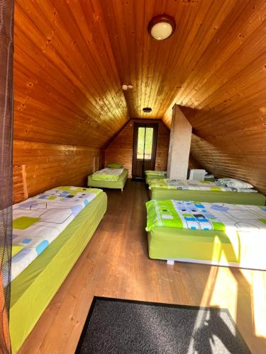 3 camas num quarto com tectos em madeira em Rõsna Puhkekeskus em Suur-Rõsna