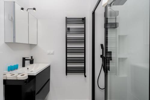 Vistula River 2-Bedroom Apartment في كراكوف: حمام أبيض مع حوض ودش
