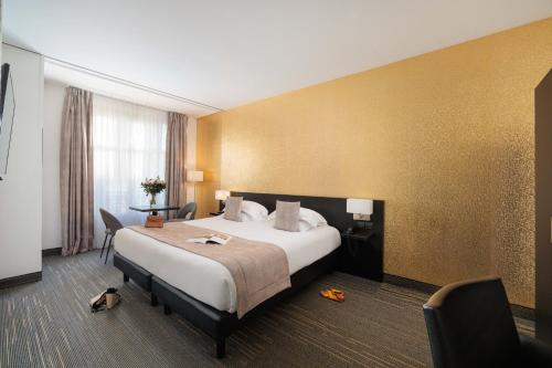 a hotel room with a large bed and a desk at Best Western Plus Hôtel Massena Nice in Nice