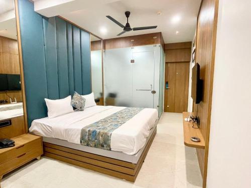 1 dormitorio con 1 cama con pared azul en Hotel Royal Elite, en Rajkot