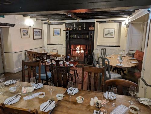 a restaurant with wooden tables and chairs and a fireplace at Bartholomew Arms in Northampton