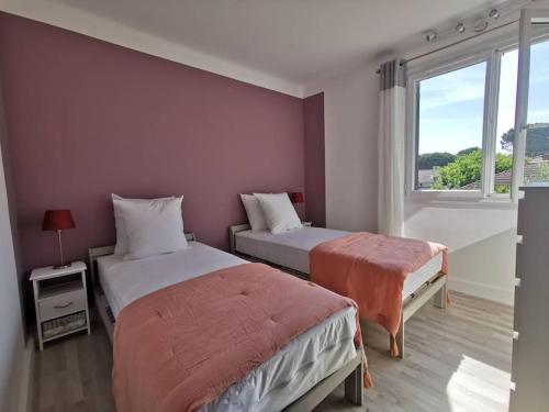 une chambre avec deux lits et une fenêtre dans l'établissement Ramadier 3 chambres climatisation 10 mn à vélo du cœur historique de la ville quartier facile à vivre, à Avignon