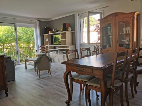 une salle à manger avec une table et des chaises en bois dans l'établissement Ramadier 3 chambres climatisation 10 mn à vélo du cœur historique de la ville quartier facile à vivre, à Avignon