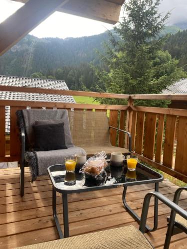 a patio with a table and two glasses of orange juice at Alpine Creek Chalet Luxury Ski-in in Morzine
